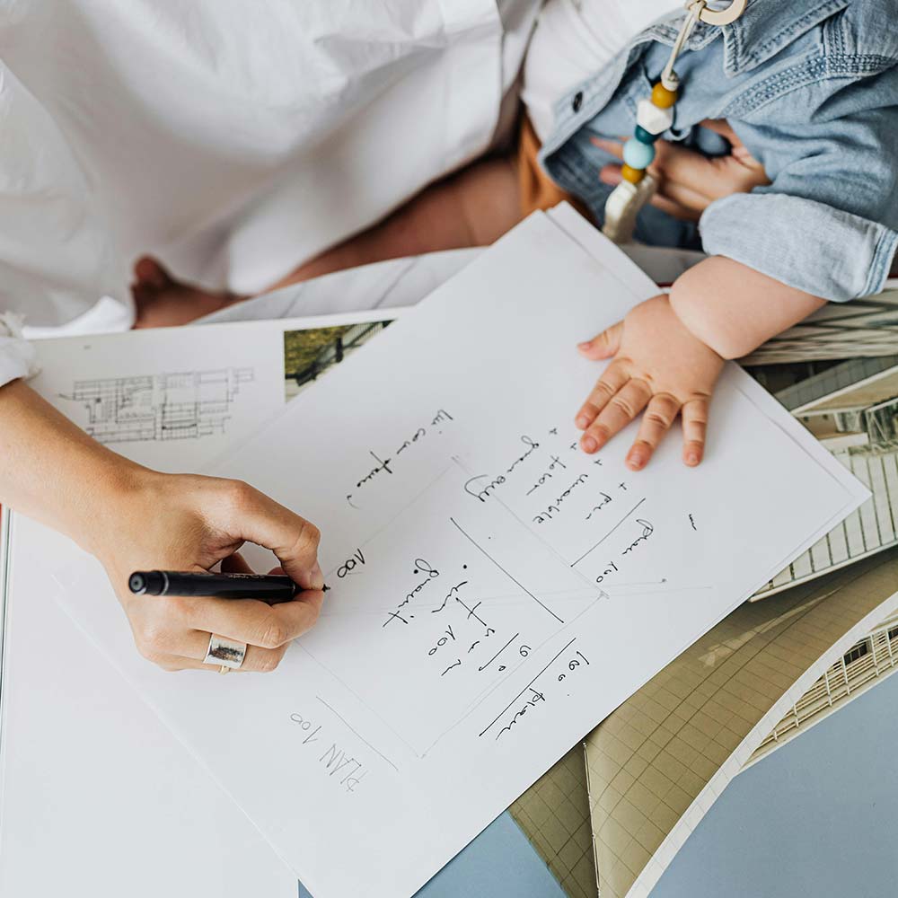 a person holding a pen and writing on a piece of paper