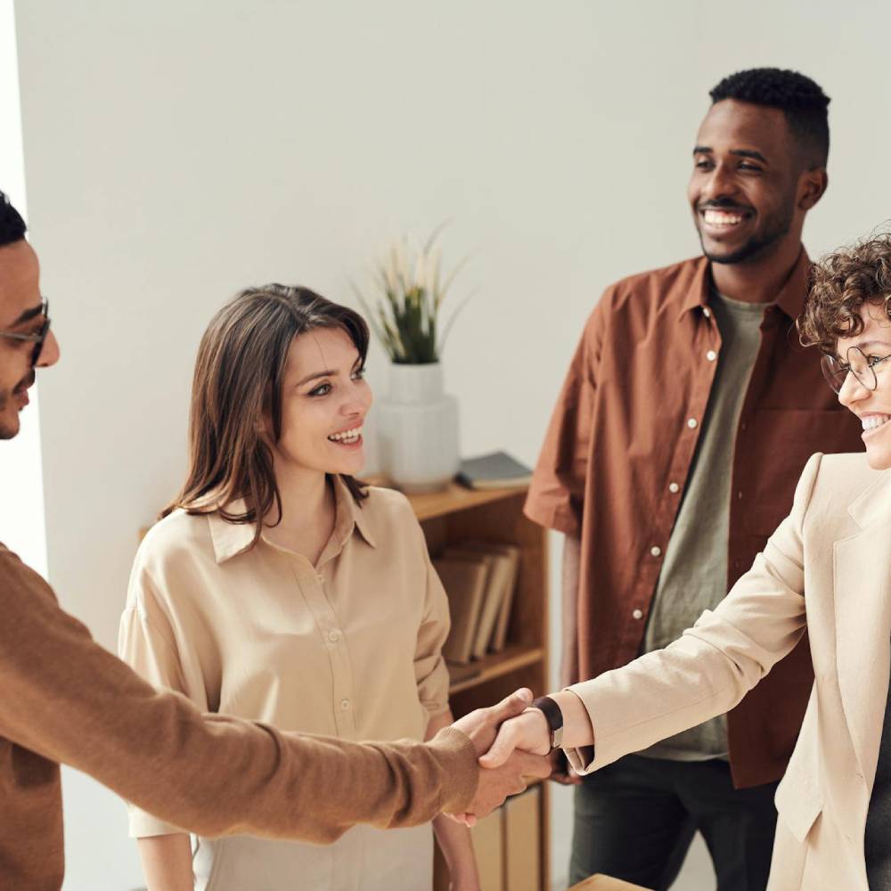 a group of 4 people with a man and woman shaking hands