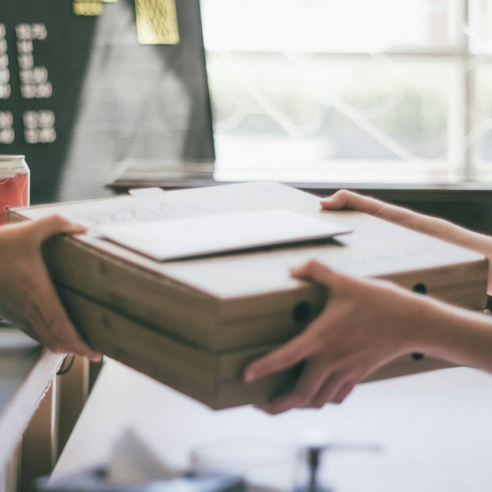a person handing another person a box of food