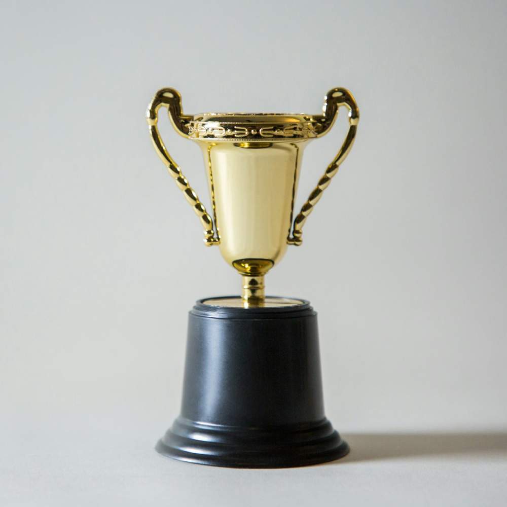 a gold trophy cup on a black base