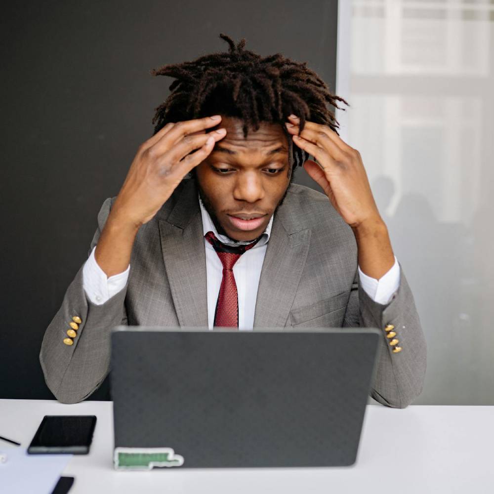 a frustrated businessman in front of a laptop