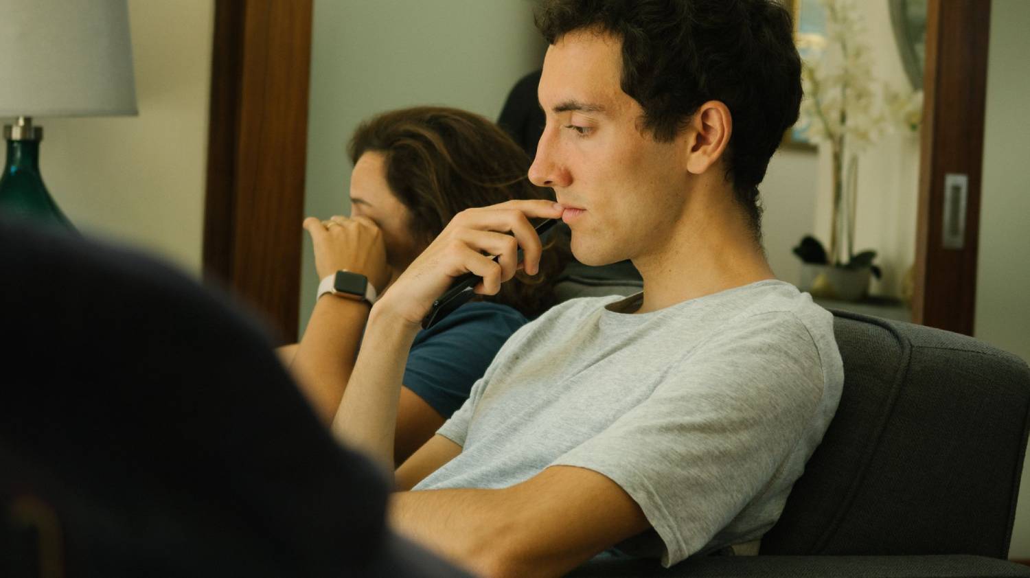 People seated in a counselling or support group setting, listening attentively during a discussion.