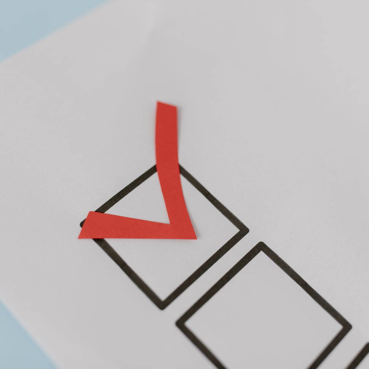 Red check mark in a checkbox on a printed checklist, symbolizing selecting or completing a task.